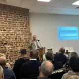Prelegent omawia strukturę prezentacji, a publiczność słucha, tworząc atmosferę wspólnego zrozumienia i **konkordancji** idei.