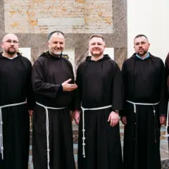 Sześciu mężczyzn w brązowych habitach, każdy z białym sznurem przepasanym w pasie. To grupa kapucynów.