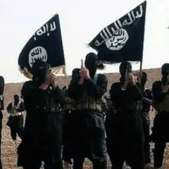 Grupa uzbrojonych mężczyzn w czarnych ubraniach i maskach, trzymających flagi z arabskim napisem, symbolizujące dżihad.
