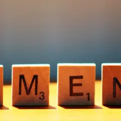 Drewniane klocki z literami A, M, E, N układają się w słowo amen.