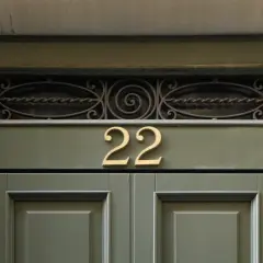 Złote liczby 22 na zielonych drzwiach. Może to znak, że czekają na Ciebie anielskie liczby i pozytywne zmiany.