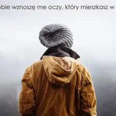 Osoba w czapce i brązowej sztruksowej kurtce patrzy w niebo, jakby szukała odpowiedzi, niczym w psalmie 150.