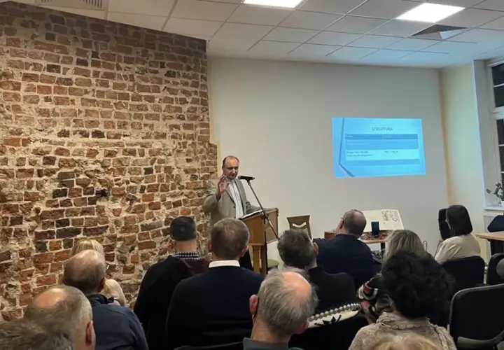 Prelegent omawia strukturę prezentacji, a publiczność słucha, tworząc atmosferę wspólnego zrozumienia i **konkordancji** idei.