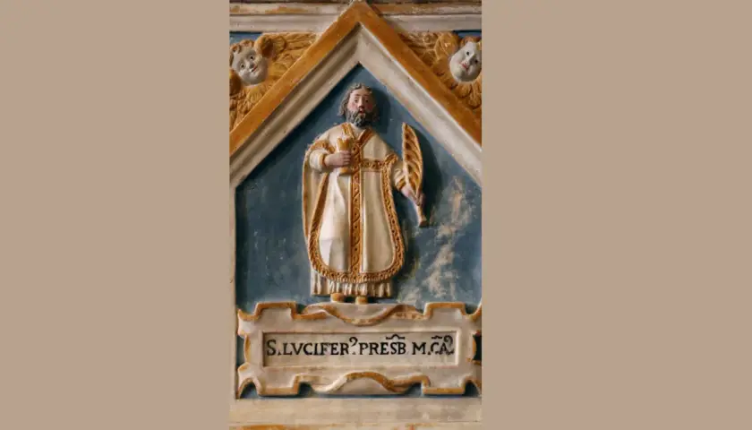 Rzeźba św. Lucifera, prezbitera, w białej szacie z palmą męczeństwa i kielichem. Nad nim dwa aniołki.