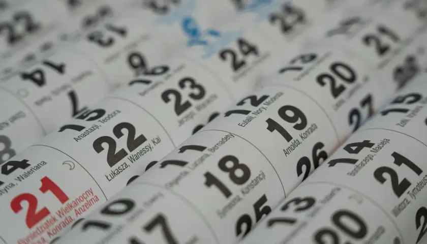 Zbliżenie na kalendarz. Widoczne daty, m.in. 21, 22, 23, 24, 25, 26, 27. Dzień 21 października jest zaznaczony na czerwono.