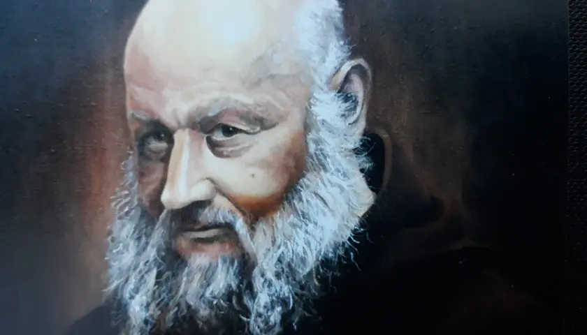 Portret starszego mężczyzny z siwą brodą i łysą głową, w ciemnej szacie.