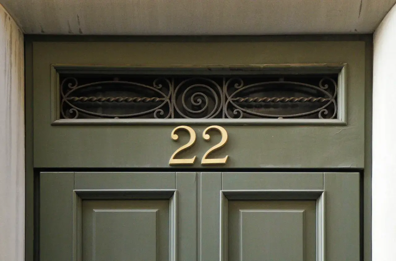 Złote liczby 22 na zielonych drzwiach. Może to znak, że czekają na Ciebie anielskie liczby i pozytywne zmiany.