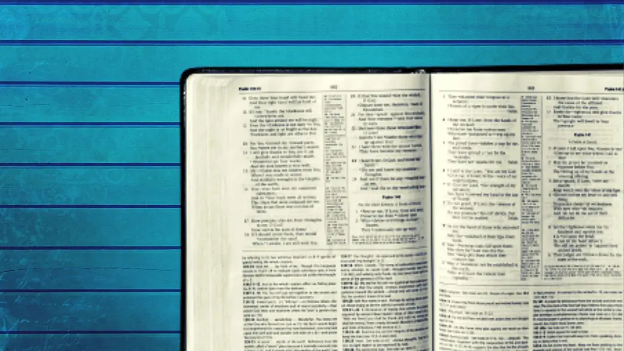 Otwarta Biblia z tekstem w języku angielskim na tle niebieskich desek.