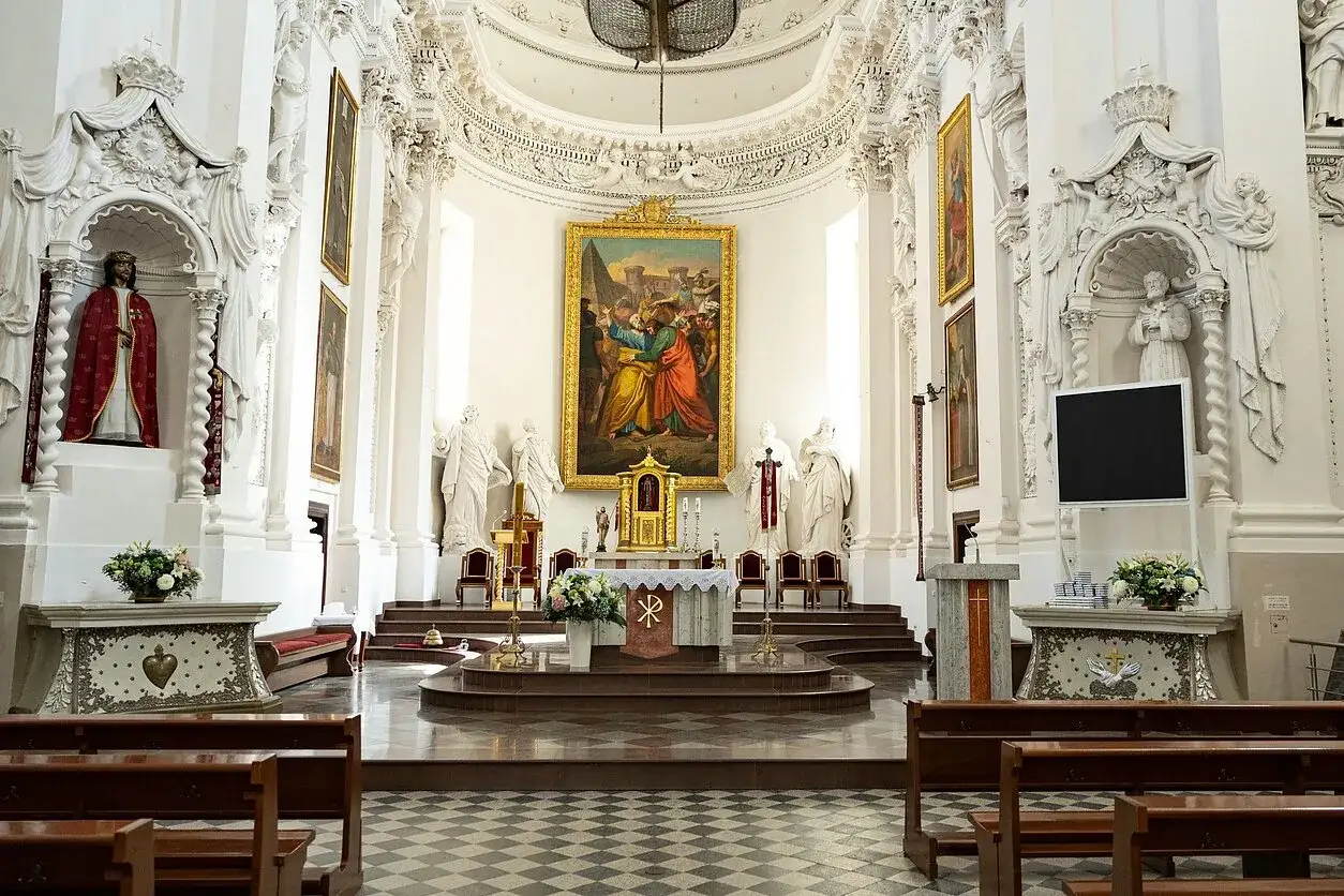 Wnętrze kościoła z ołtarzem, obrazem i rzeźbami. Okres sede vacante, gdy tron papieski jest pusty, może być czasem refleksji w takich miejscach.