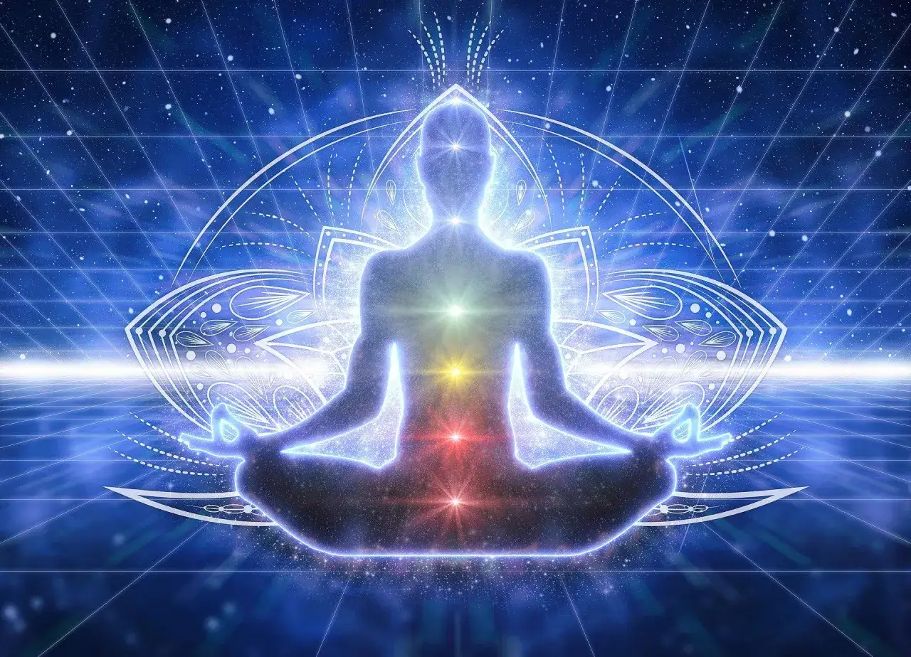 Sylwetka w pozycji medytacyjnej, z widocznymi czakrami. Obraz symbolizuje przebudzenie kundalini co to jest i jak działa.